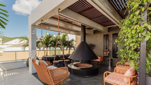 An outdoor seating area with wicker chairs and a central fire pit. - Full Apartment at Ingleses Beach-sc Gge203 (Florianópolis)