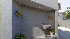 A modern outdoor bathroom with a white sink and potted plants. - Cozy Apartment Less Than 100 m From the Beach Gdi2 (Florianópolis)