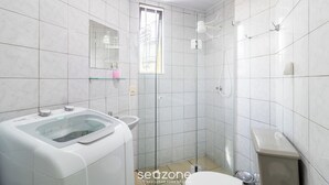 A modern bathroom with a glass-enclosed washing machine, a sink, and a toilet. - Cozy Apartment Less Than 100 m From the Beach Gdi2 (Florianópolis)
