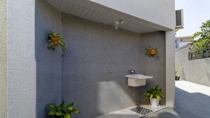 A modern outdoor bathroom with a white sink and potted plants. - Cozy Apartment Less Than 100 m From the Beach Gdi2 (Florianópolis)