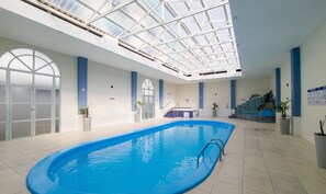 An indoor swimming pool with a skylight ceiling, a hot tub, and potted plants. - Charming Stay Steps From the Sea Ftm0401 (Florianópolis)
