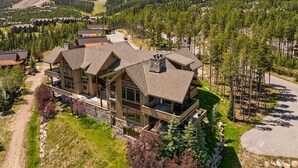A large lodge with multiple guest rooms, a ski lift in the background, and a mountainous landscape. - Cowboy Lux - Moonlight Basin Ski In/Out (Big Sky)