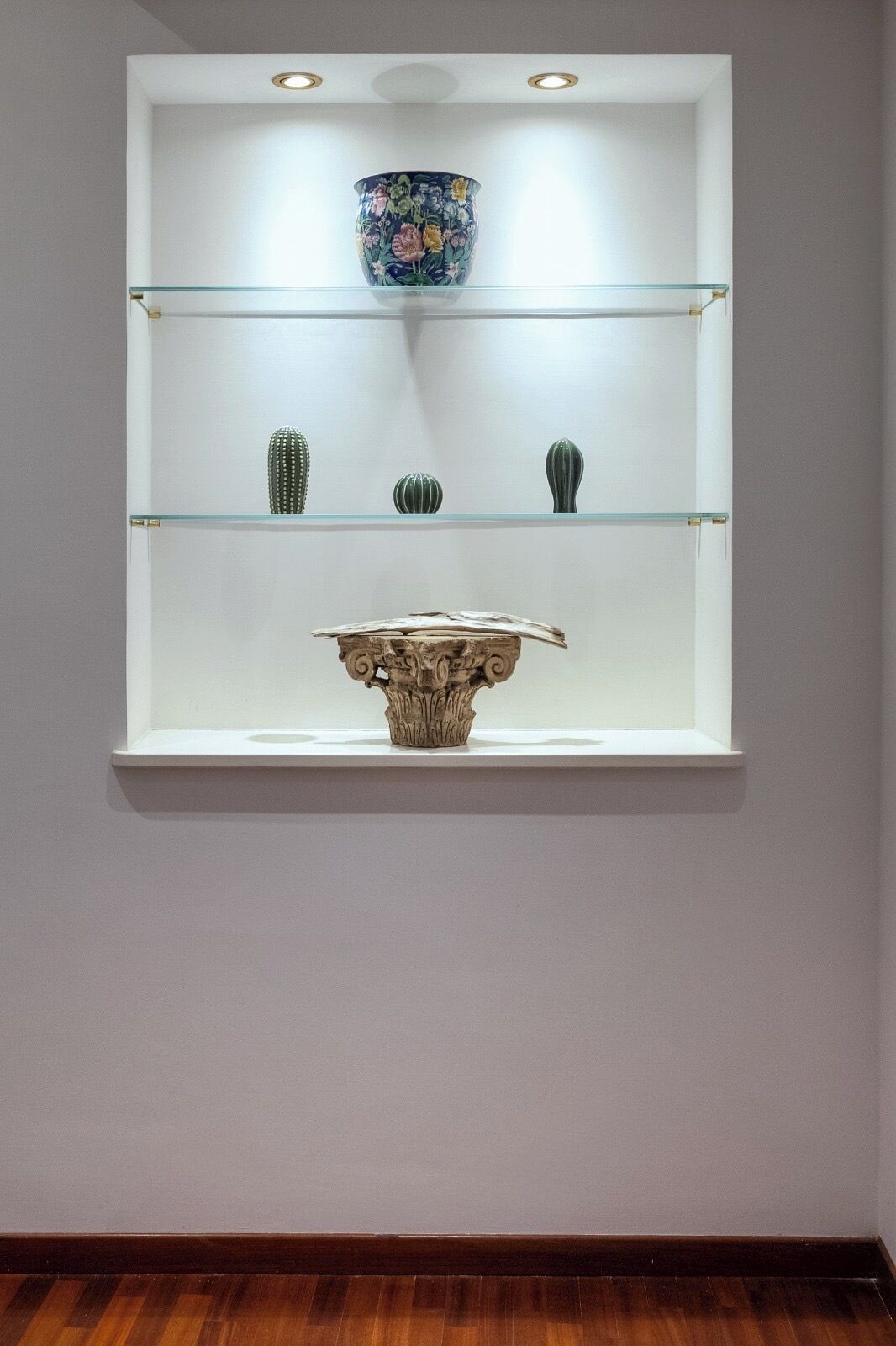 Une étagère décorative ornée d’un vase, de deux petits vases et d’une sculpture.