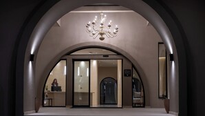 A hotel lobby with a grand arched entrance, a chandelier, and a reception desk. - The Landmark Villas & Spa (Rhodes)
