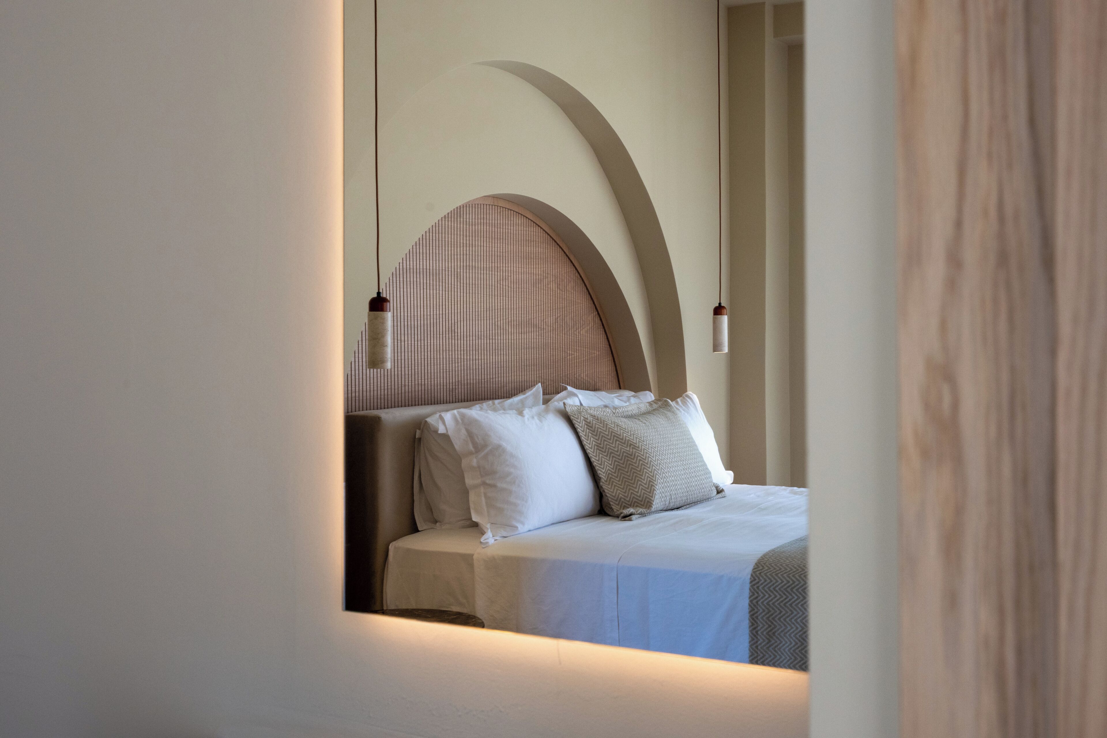 Una camera da letto con un letto, cuscini e una testiera.