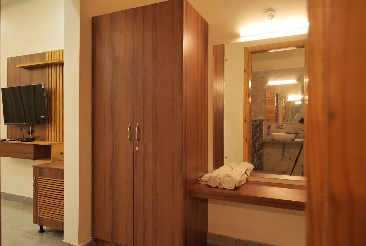 Een moderne badkamer met houten kastjes, een spiegel en een wastafel.