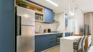 Cozinha moderna com frigorífico embutido, micro-ondas e fogão.