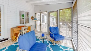 A room with a white wooden interior, a desk with a chair, a blue sofa, and a table with a lamp. - Mashpee Heaven Lake front (Mashpee)