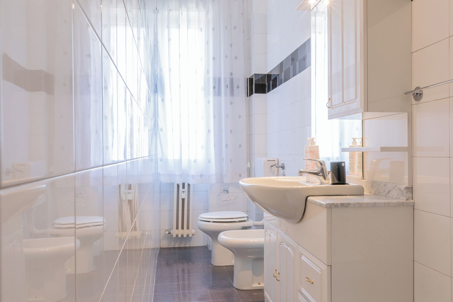A modern bathroom with a glass shower enclosure, a white sink, and a toilet.