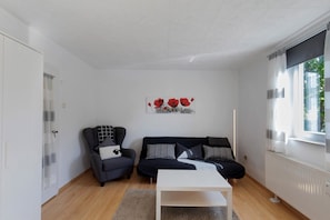 Una sala de estar moderna con sofá, sillón y una mesa de centro.