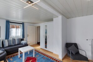 A modern living room with a sofa, a coffee table, a chair, and a wardrobe.