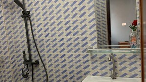 Ein Badezimmer mit Dusche, Waschbecken und Spiegel.