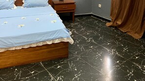 Ein Schlafzimmer mit Bett, Nachttisch und einem Fenster mit Vorhängen.