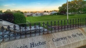 Un monumento in pietra con l'iscrizione 'Hyannis Harbor - Gateway to the Sea', una bandiera americana e un cielo sereno.
