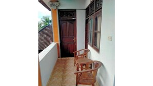 A balcony with a tiled floor, a wooden door, and two wooden chairs. - Soothing apartment with AC in charming Darmasaba (Darmasaba)