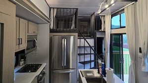 A compact kitchen with modern appliances, a built-in oven, and a stainless steel refrigerator.