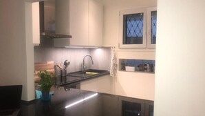 A modern kitchen with a black countertop, stainless steel appliances, and a window with a view. - Enchanting apartment with AC in Cannes (Cannes)