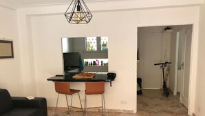 A modern living space with a kitchen area, a dining table with two chairs, and a black sofa. - Enchanting apartment with AC in Cannes (Cannes)