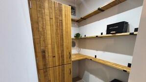 A corner of a room with wooden cabinetry and a black storage unit. - Lime Tree House - Sleeps 12 - Hot Tub (Sudbury)
