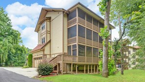 A multi-story building with a balcony on the second floor, a stone foundation, and a driveway leading to the entrance. - Riverside Trout Cottage / Sleeps 8 / Short walk to Downtown Helen (Helen)