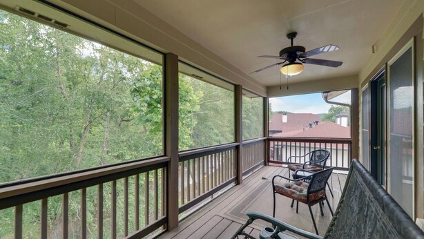 A covered porch with a ceiling fan, a table with chairs, and a view of a wooded area. - Riverside Trout Cottage / Sleeps 8 / Short walk to Downtown Helen (Helen)