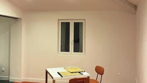 A room with a white table, a chair, a window, and a door. - T2 Design - Montpellier Centre (Montpellier)