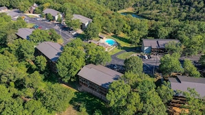 Vista aérea de una zona residencial con varias casas, una piscina y un amplio espacio verde.