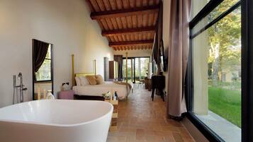 Un baño espacioso con una bañera grande, zona de ducha y ventana con vistas al exterior.