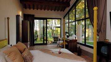 Ein Schlafzimmer mit einem großen Bett, einem Schreibtisch und Blick ins Freie.