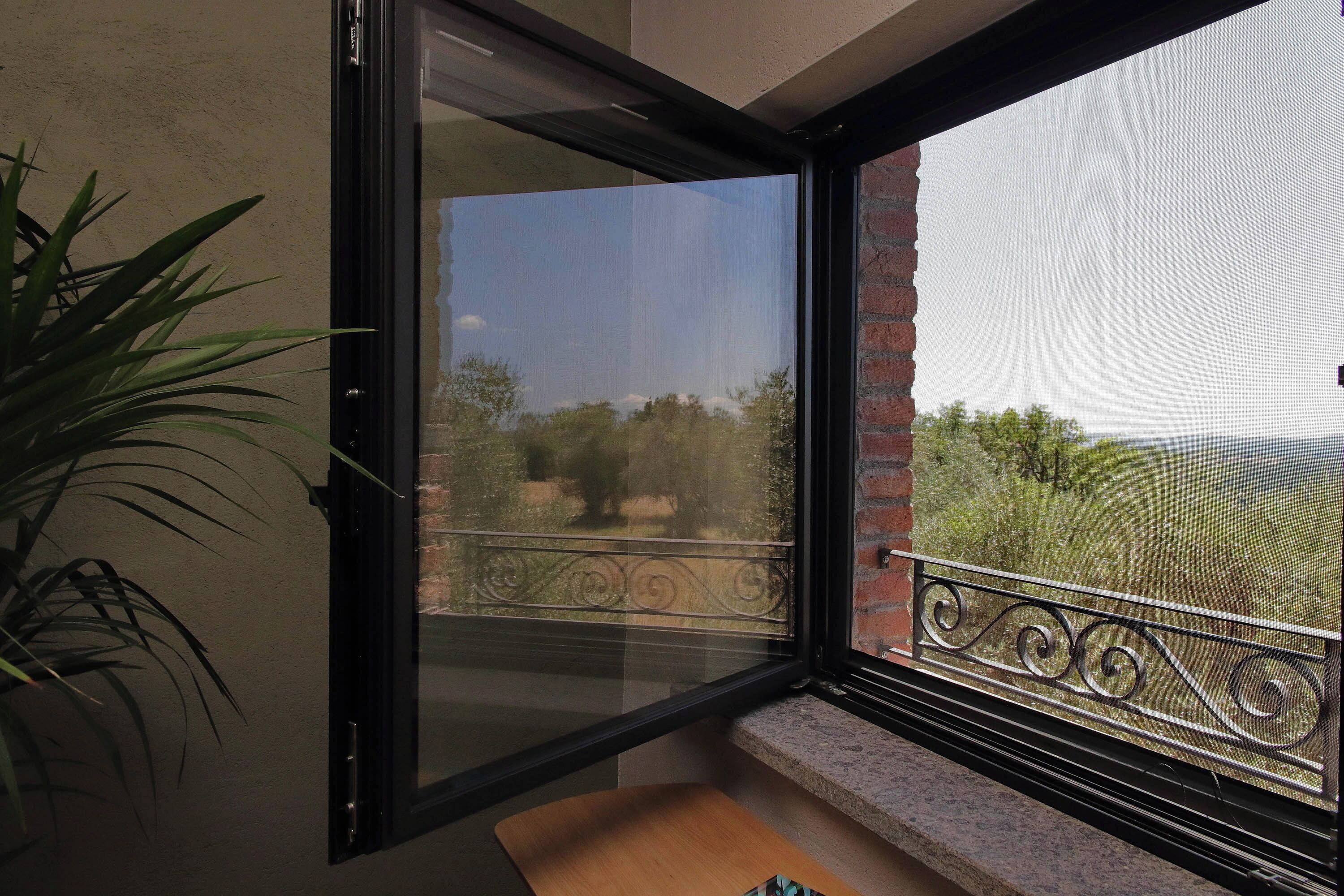 A balcony with a view of trees and mountains.