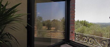 A balcony with a view of trees and mountains.