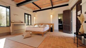 Une chambre à coucher avec un lit, des tables de chevet, une fenêtre et une porte.