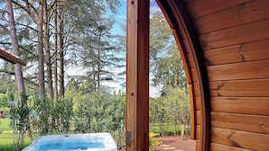 Une cabane en bois avec un jacuzzi dans un jardin.