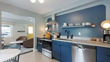 A modern kitchen with blue cabinets, stainless steel appliances, and a white countertop.
