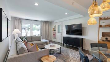 A modern living room with a sofa, coffee table, and TV.