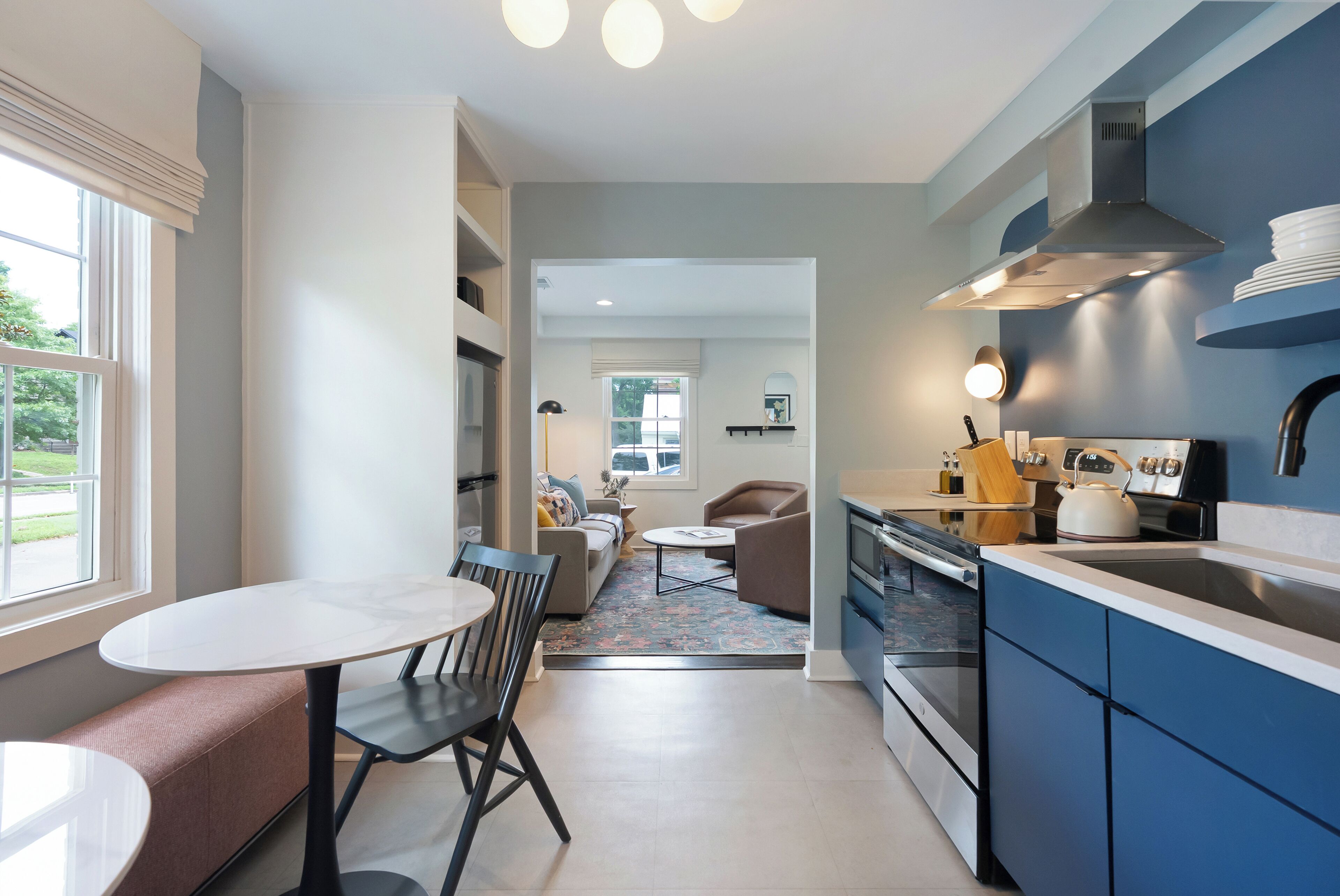 Une cuisine moderne avec un coin repas, un canapé et une vue sur l’extérieur.