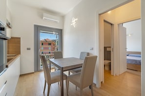 Un appartement moderne comprenant un coin repas, une kitchenette et une chambre.
