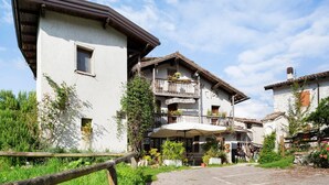 A traditional building with a balcony, outdoor seating, and a gravel path. - Room 'Camera 2' with Mountain View, Shared Garden and Wi-Fi (Arsiè)