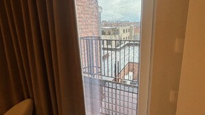 A room with a sliding glass door leading to a balcony with a metal railing. - Manteka Logies (Ypres)