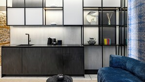 A modern kitchen with a dark countertop, a sink, and a built-in shelving unit with decorative items.