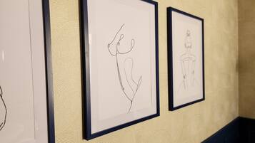 Three framed line drawings on a textured wall.