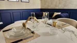 A round dining table set with clear glassware, gold accents, and a marble surface. - The Volupté Suite - Luxury, calm and romance with private sauna and Jacuzzi (Doué-en-Anjou)