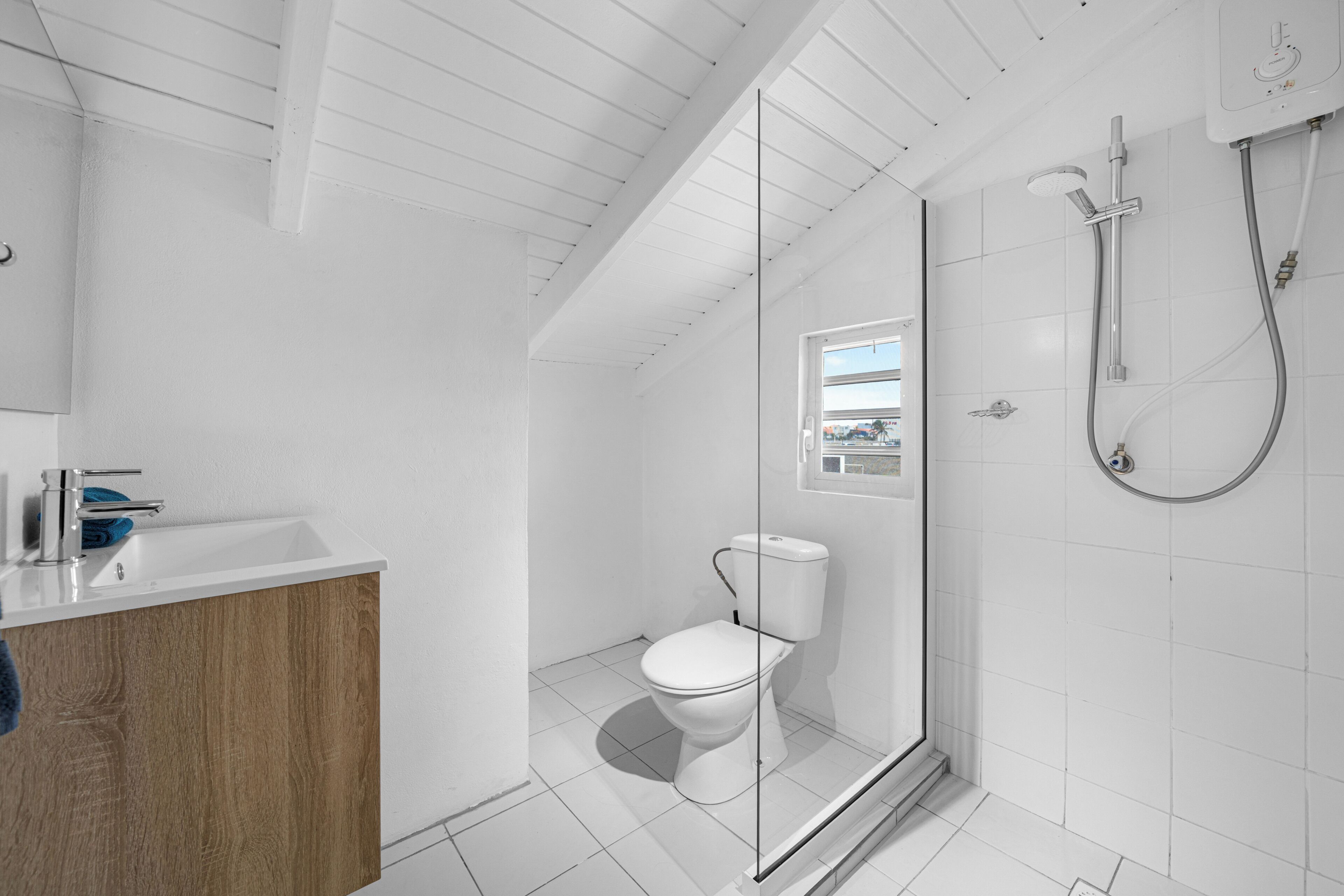 A modern bathroom with a shower, toilet, and sink.