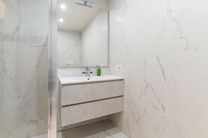 Een douche, een bidet, handdoeken, toiletpapier