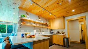 A modern kitchen with wooden cabinets, a central island, and built-in shelves.