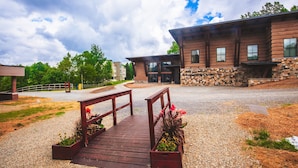 A building with a stone facade and wooden deck leading to the entrance.