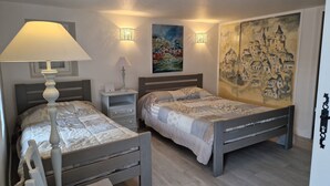 A bedroom with two beds, a nightstand, a lamp, and a painting on the wall. - CHAMBRE D'HÖTE AT THE FOOT OF THE CHATEAU SLIDING-SCALE RATES PLUS 2 NIGHTS WEEKEND INCLUDED (Castelnaud-la-Chapelle)