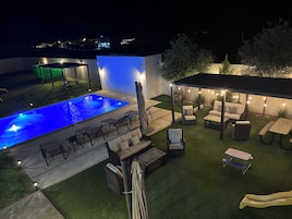 Una piscina al aire libre, camas de piscina gratis, sombrillas