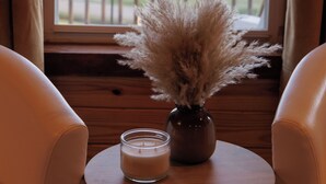 A room with a wooden table, a vase with dried pampas grass, and a candle. - Gulf Views, Game Room, Fire Pit, Walk to Boat Launch and Pier, Near Down Town (Ocean Springs)
