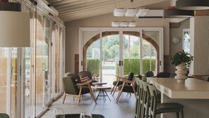 A modern dining area with a long table, chairs, and a bar counter. - wecamp Jávea (Javea)